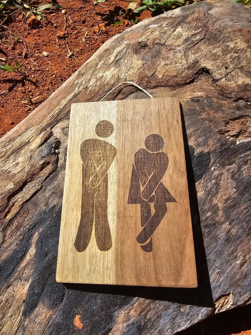 Señalética de baños grabada en madera tratada.